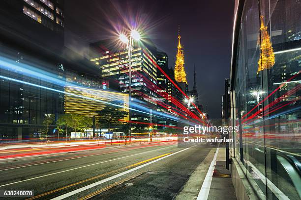 city street showing traffic flow lines with long exposure - avenida paulista stock pictures, royalty-free photos & images