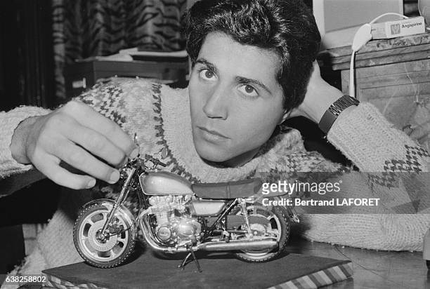 Jean-Luc Lahaye avec un modèle réduit d'une moto dans son appartement à Paris, France, en octobre 1982.