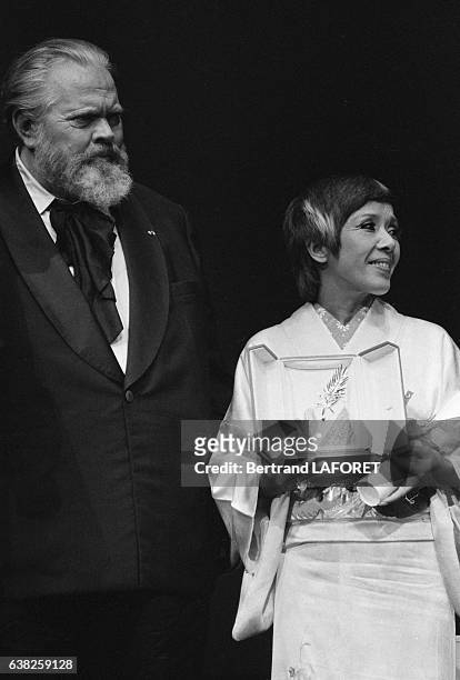 Shohei Imamura reçoit la Palme d'Or des mains d'Orson Welles lors de la soirée de clôture du Festival de Cannes le 19 mai 1983, à Cannes, France.