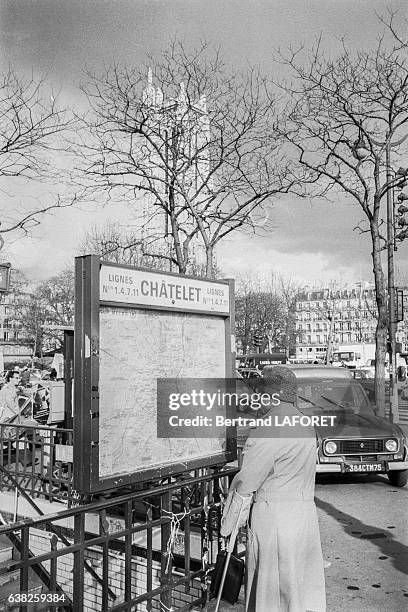 Un homme regarde le plan de métro à l'entrée de la station Châtelet le 22 mars 1983 à Paris, France.
