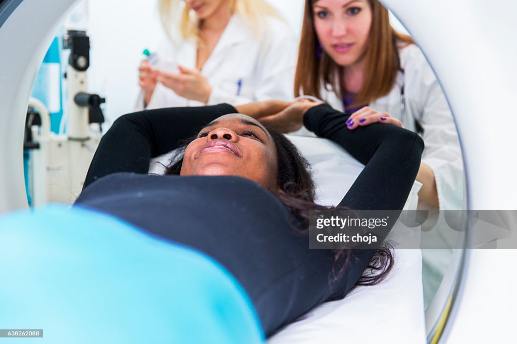 Young black woman waiting for CAT scan with contrast