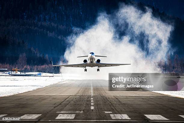 business jet departing a snowy airfield - airfield stock pictures, royalty-free photos & images
