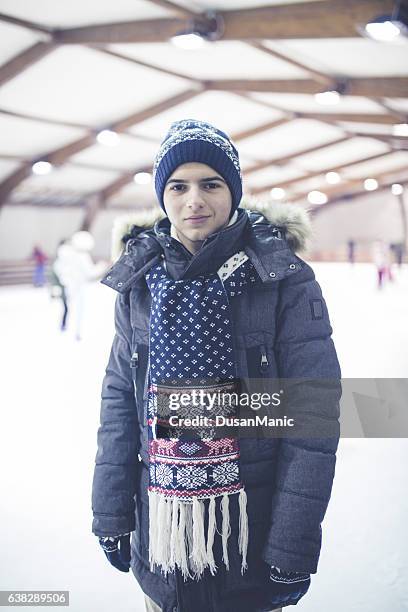 glücklicher junger mann auf eisbahn - ice hockey glove stock-fotos und bilder