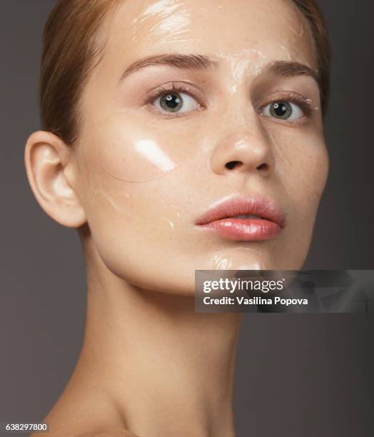 beautiful woman with skin care products on her face - esfoliazione foto e immagini stock