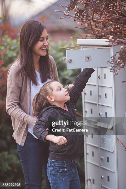 an ethnic mother is getting the mail with her young - hawaiian girls stock pictures, royalty-free photos & images