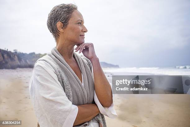 femme noire senior se relaxant sur la plage - zen attitude photos et images de collection