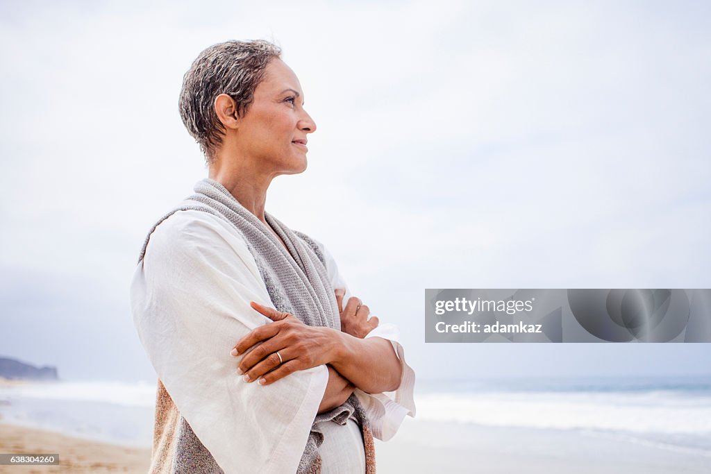 Ältere schwarze Frau, die sich am Strand entspannt