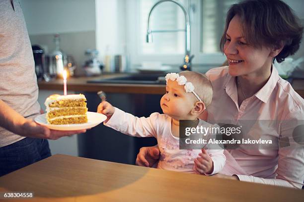 family celebrating first birthday at home - iakovleva stock pictures, royalty-free photos & images