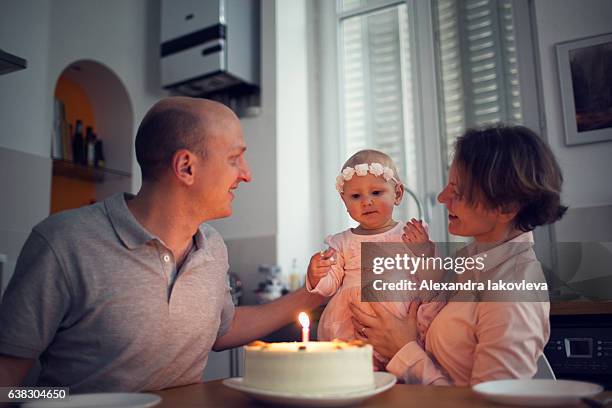 family celebrating first birthday at home - alexandra iakovleva stockfoto's en -beelden
