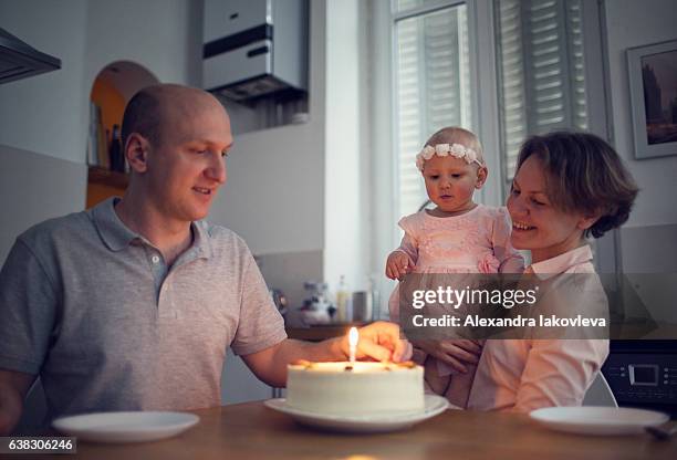 family celebrating first birthday at home - iakovleva stock pictures, royalty-free photos & images