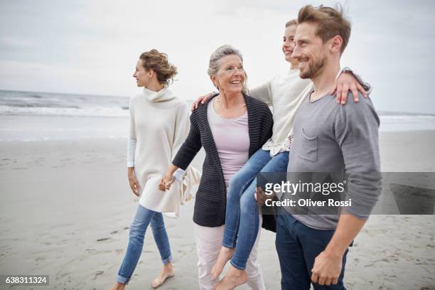 happy three-generation family on the beach - family trip in laws stock pictures, royalty-free photos & images