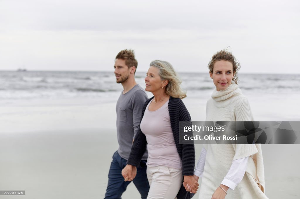 Couple with senior woman walking on the beach