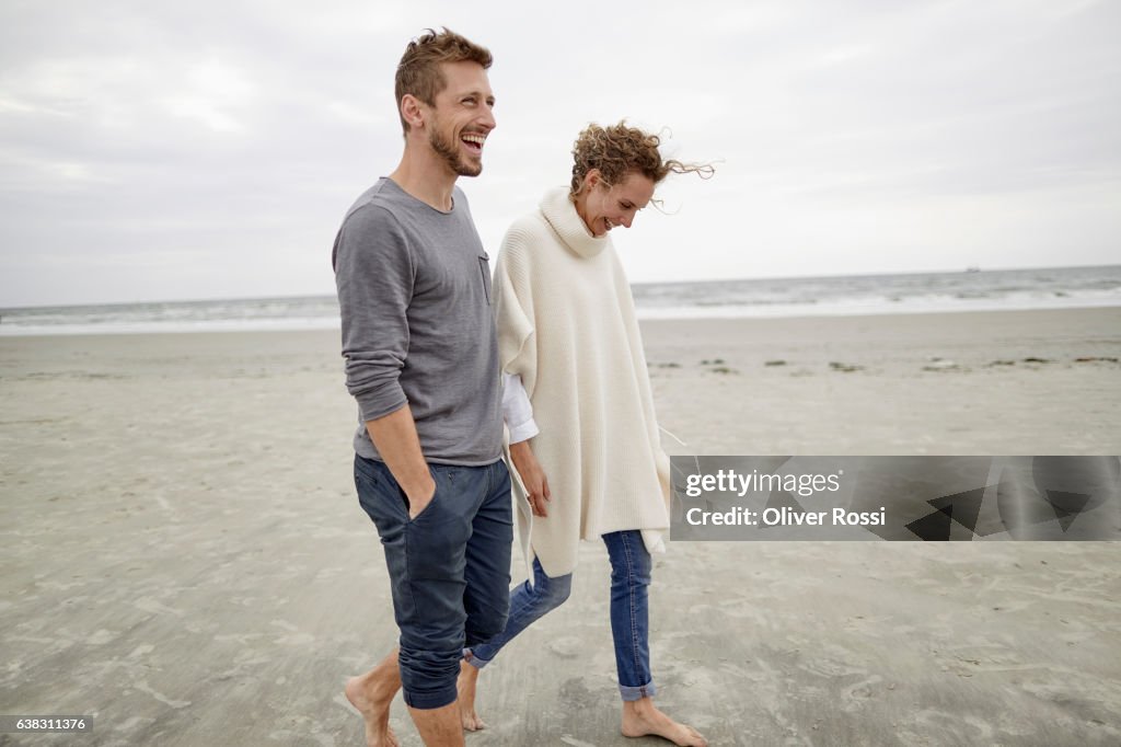 Happy couple walking on the beach
