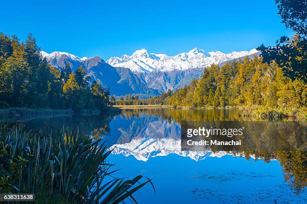 reflection of mountains in the lake matheson, new zealand - new zealand imagens e fotografias de stock