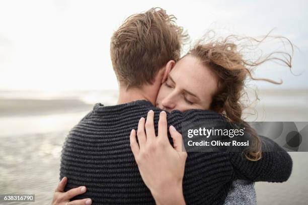couple hugging on the beach - relazione umana foto e immagini stock