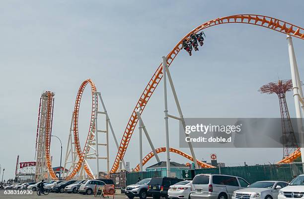 people having fun in thunderbolt rollercoaster, coney island - rollercoaster loop stock pictures, royalty-free photos & images