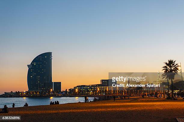 sunset at barceloneta beach, barcelona, spain - barcelona spain stock pictures, royalty-free photos & images