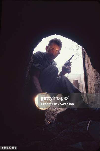 Sergeant C Domingue, a 'tunnel rat' from the 588th Engineer Battalion, searches tunnels in the Iron Triangle area near Ben Suc, during Operation...