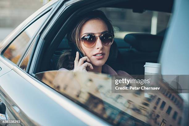 young woman with phone on the back seat - rich people imagens e fotografias de stock