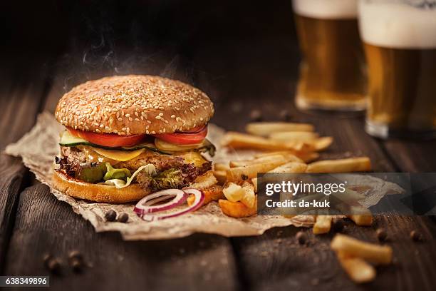 hamburger gustoso con patatine fritte e birra su tavolo di legno - bbq sandwich foto e immagini stock