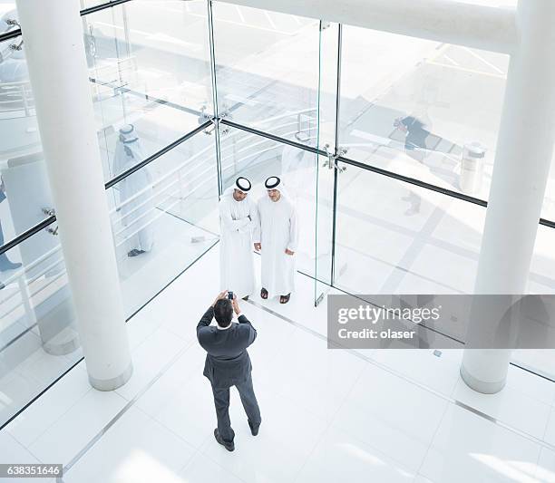 three arab business men taking a picture - lypseuae2015 stock pictures, royalty-free photos & images
