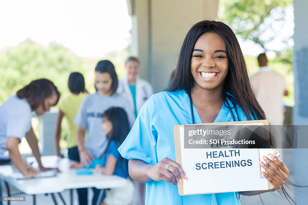 Alegre joven enfermera afroamericana promueve feria de salud