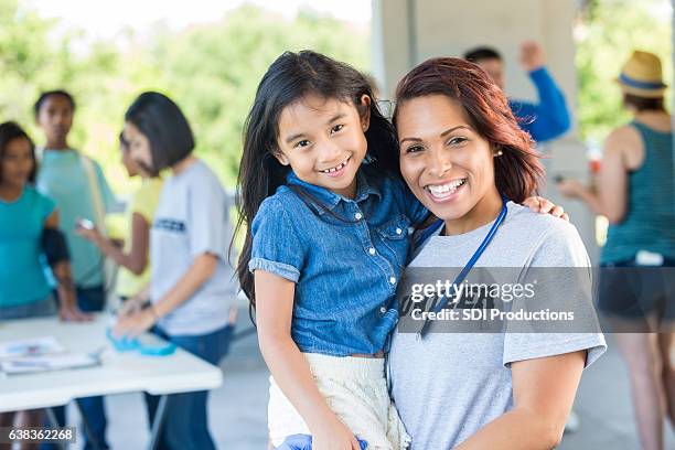 happy volunteer physician with young patient - expo 2017 stock pictures, royalty-free photos & images