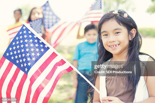 かわいいフィリピンの女の子は屋外でアメリカの旗を保持しています - asian flags ストックフォトと画像