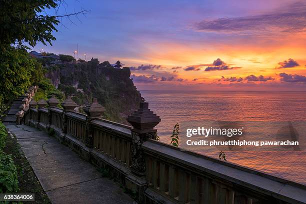 walkway to uluwatu temple at twilight, bali indonesia. - uluwatu stock pictures, royalty-free photos & images