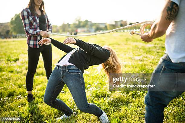 gruppe von menschen spielen limbo auf dem park - limbo stock-fotos und bilder