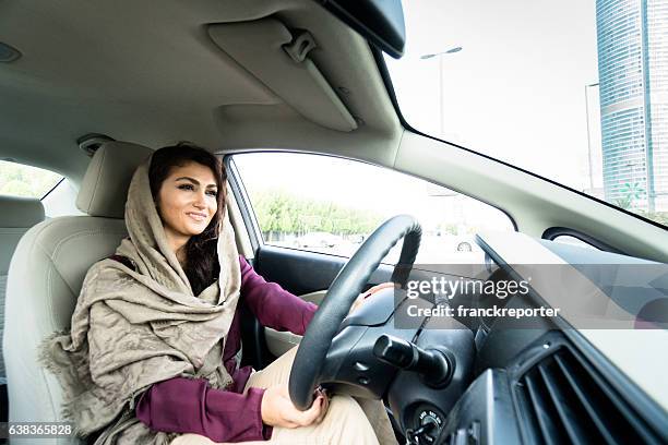 frau fährt das auto in abu dhabi - arab driving stock-fotos und bilder