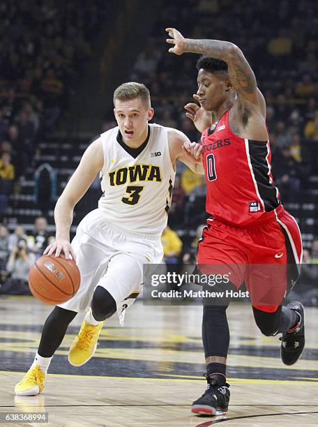 Guard Jordan Bohannon of the Iowa Hawkeyes drives down the court in the first half against guard Nigel Johnson of the Rutgers Scarlet Knights, on...