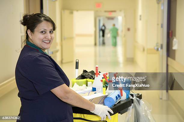 custodian janitor in hospital hallway with cart - mid adult women stock pictures, royalty-free photos & images