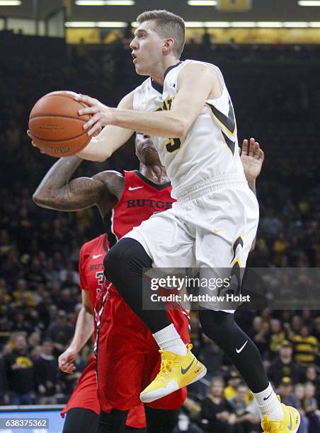 Guard Jordan Bohannon of the Iowa Hawkeyes goes to the basket in the second half against guard Nigel Johnson of the Rutgers Scarlet Knights, on...