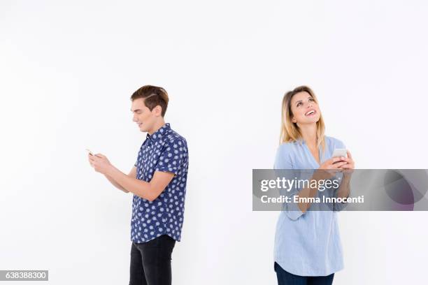 man and woman using smartphones - man blouse stock pictures, royalty-free photos & images