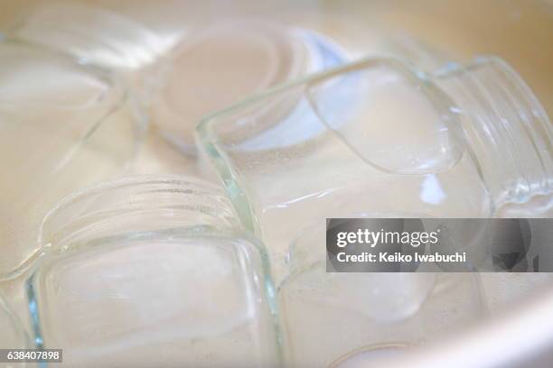 sterilizing glass bottles in boiling water. - marmeladenglas stock-fotos und bilder