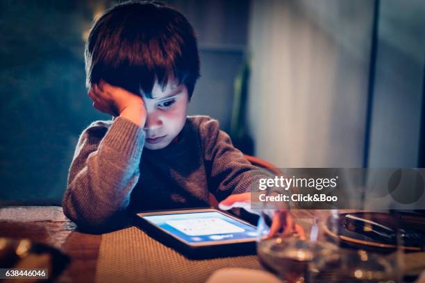 concentrated boy with a tablet - new technologies - oscuro bildbanksfoton och bilder