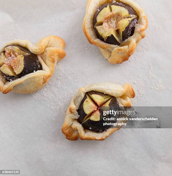 three fresh figs packed with puff pastry. - tarte tatin stock-fotos und bilder