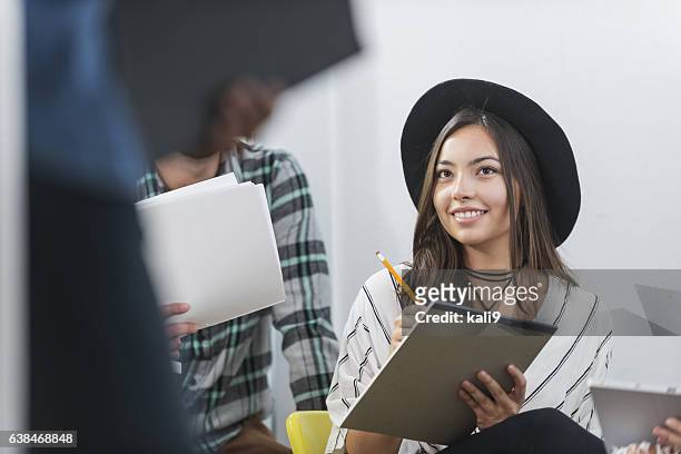 young hispanic woman taking notes in meeting - internship marketing stock pictures, royalty-free photos & images