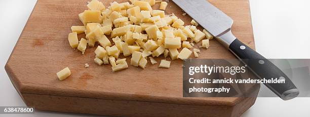 chopped cantal cheese on wooden chopping board. - cantal stockfoto's en -beelden