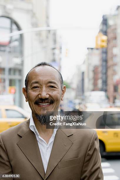 portrait of asian mature man in downtown city - new yorker building 個照片及圖片檔