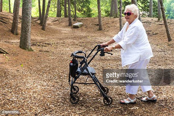 pushing walker through a forest - mobility walker stock pictures, royalty-free photos & images