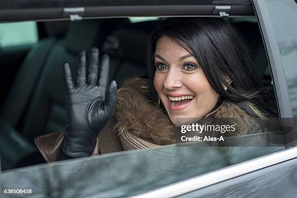 smiling woman waving through a car window - long leather gloves stock pictures, royalty-free photos & images