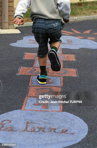 Enfant jouant à la marelle pendant la rentrée scolaire le 10 septembre 1991 en France.