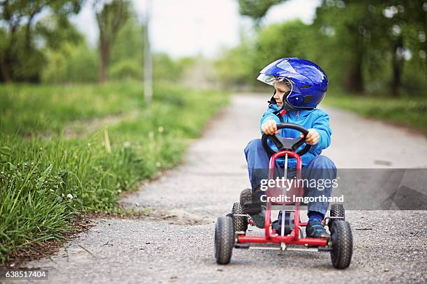 portrait of little boy riding a go-kart. - go kart pics stock pictures, royalty-free photos & images