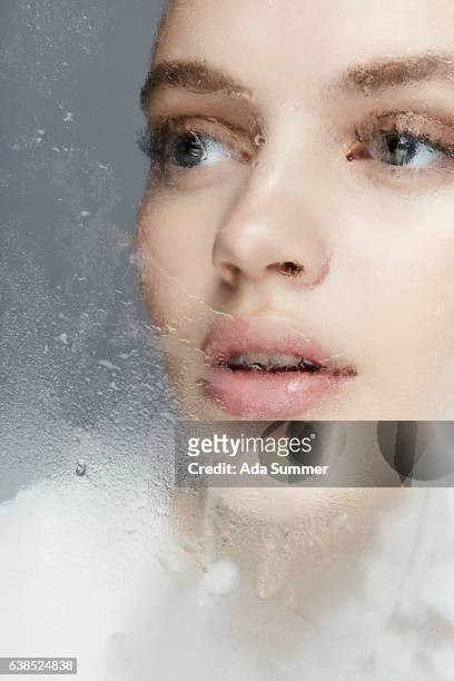 beautiful woman behind frosted glas - menschliches gesicht fotografías e imágenes de stock