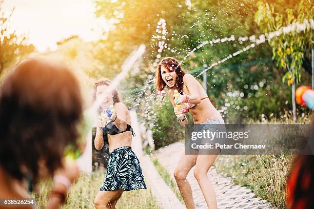 teenage girls playing with water guns - water pistol stock pictures, royalty-free photos & images