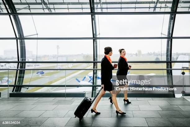 two flight attendants on the way to their plane - crew stock pictures, royalty-free photos & images