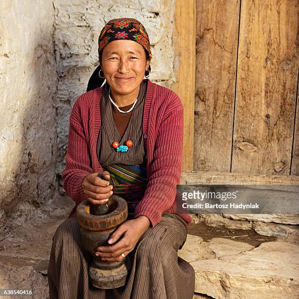 tibetan woman using a mortar to make  flour. mustang, nepal - nepal food stock pictures, royalty-free photos & images