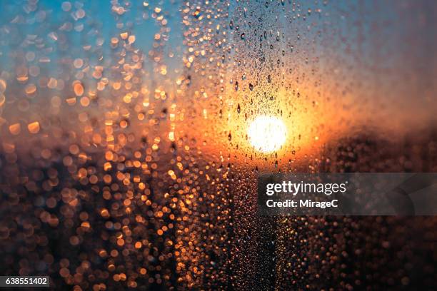 winter sunrise with condensation water dew on window - winter and warm glow stock-fotos und bilder